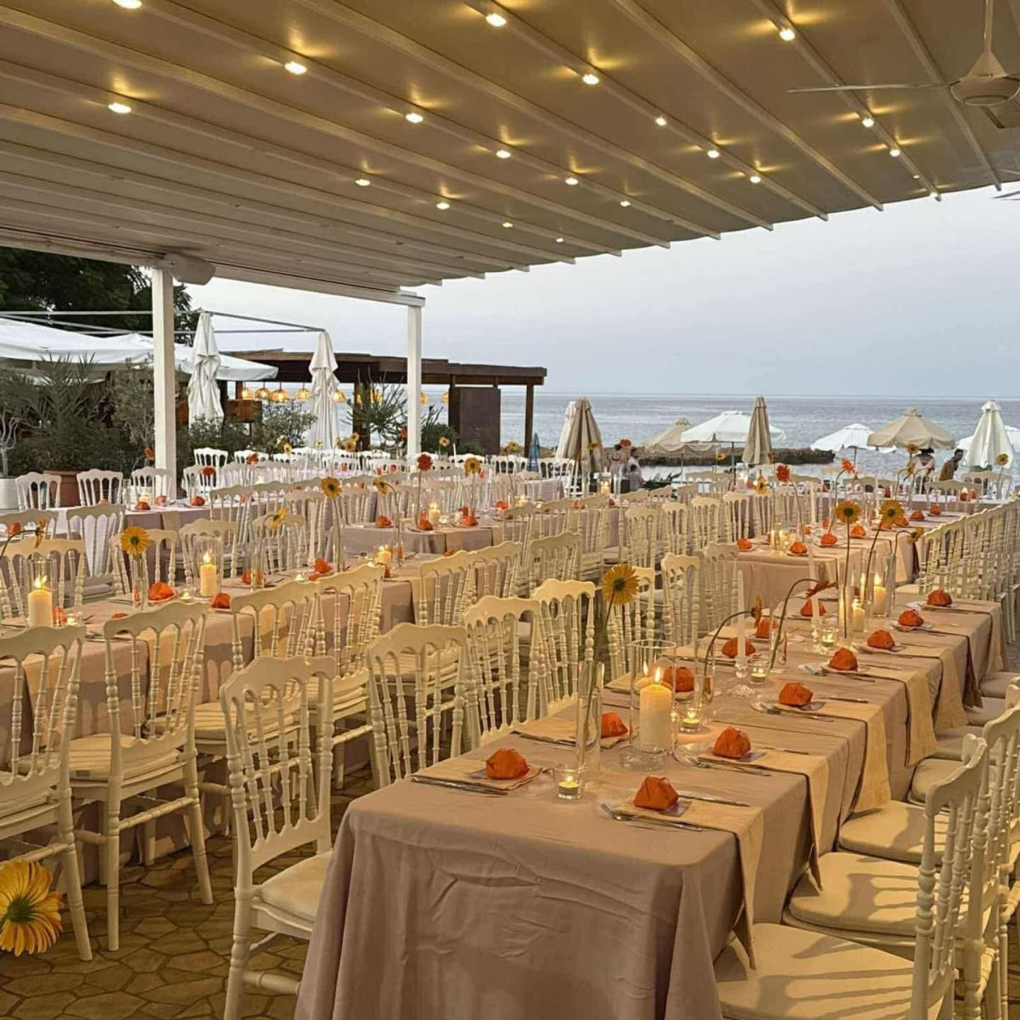 rows-of-white-chiavari-chairs-long-tables-cutlery-glasses-with-textiles rows of white chiavari chairs beside long tables with cutlery, glasses and textiles